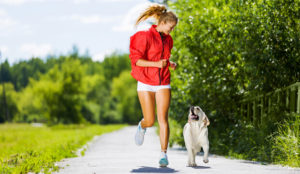 A woman jogging with a dog