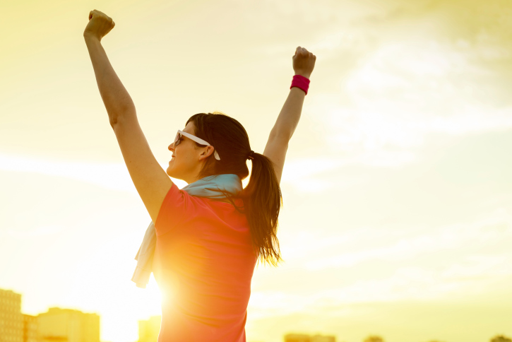 Sportswoman with arms up celebrating success